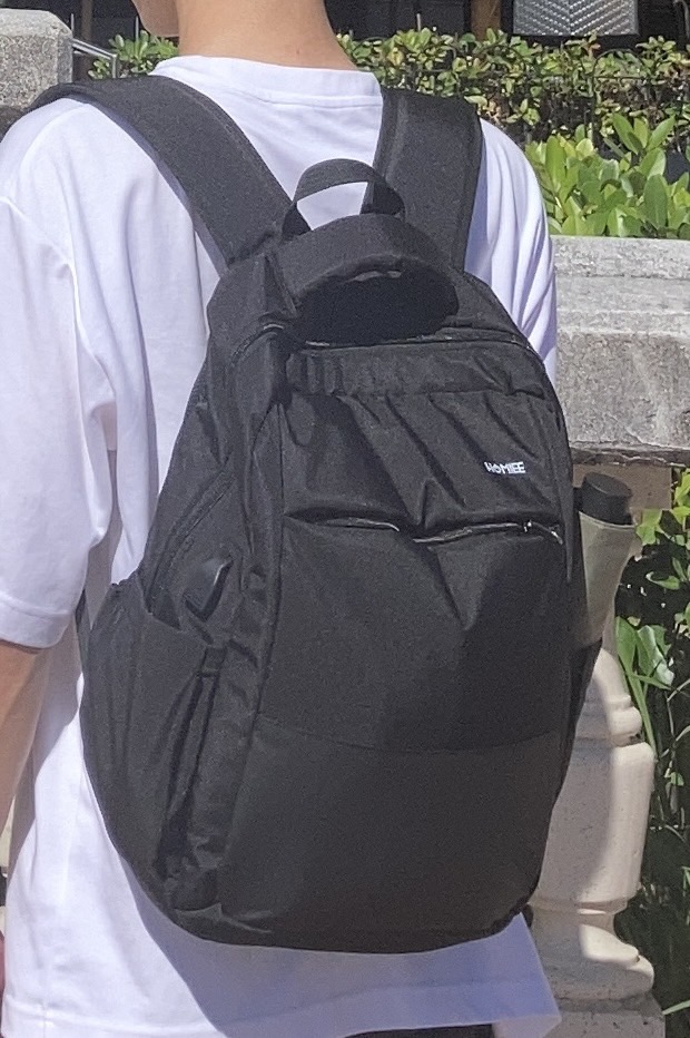 HOMIEE ビジネスリュックを背負って斜め左を向いている